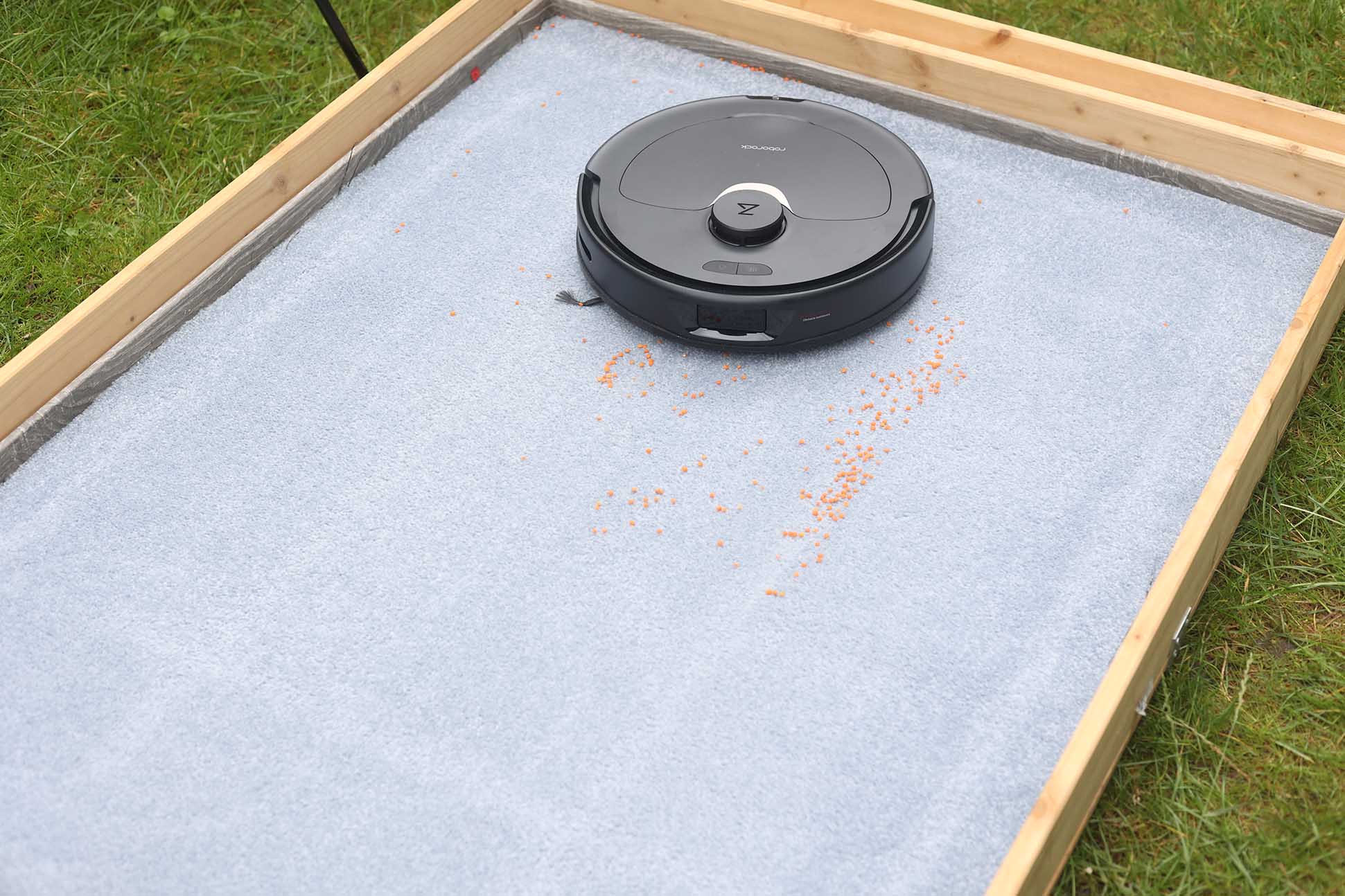 Roborock Q Revo во время испытаний на уборку чечевицы на ковре с высоким ворсом.